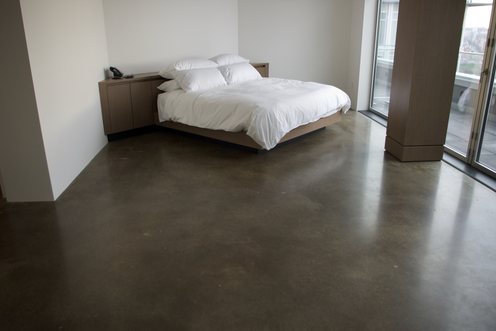Private residence bedroom with polished concrete floor.