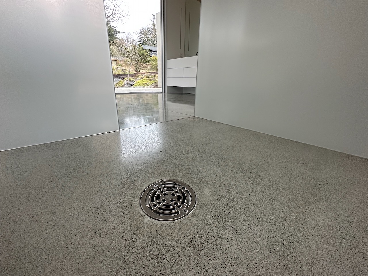curb less polished concrete shower with drain. the floor is heated.